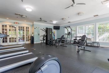 A gym with treadmills, weights, and exercise equipment.